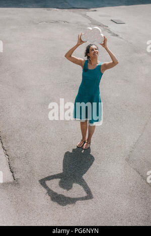 Femme debout dans la cour, en altitude, symbole nuage holding smiling Banque D'Images