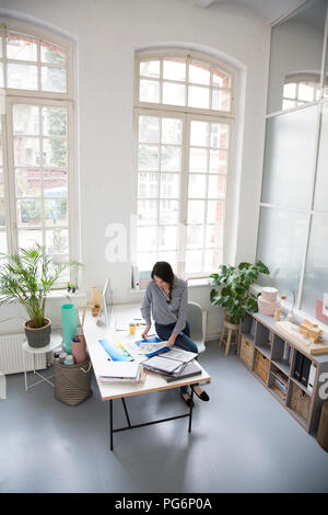 Femme travaillant au bureau dans un bureau loft Banque D'Images