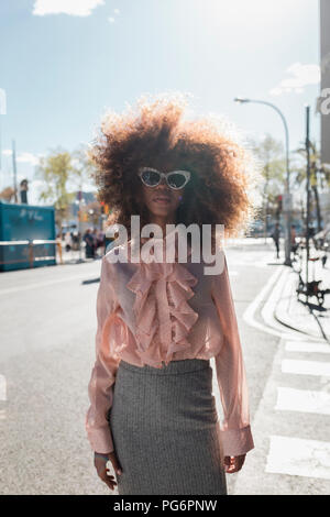 Portrait de la belle jeune femme à la coiffure afro dans la ville Banque D'Images