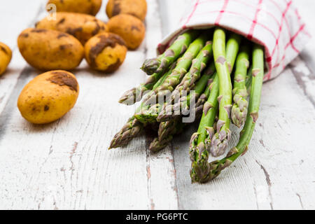 Les asperges vertes et les pommes de terre sur le bois blanc Banque D'Images