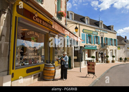 Femme femme wine buyer visiteur navigue sur des bouteilles de vin sur l'affichage à l'extérieur de la boutique de vins 'Cave des Vieilles Vignes', Meursault village, Bourgogne France Banque D'Images