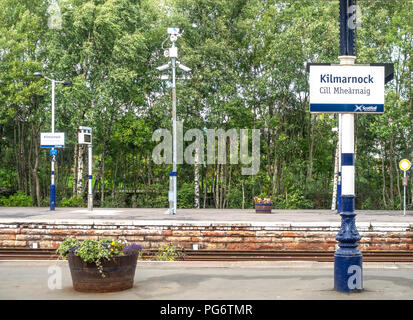 Deux plates-formes de Kilmarnock Gare dans East Ayrshire, avec l'affichage bilingue : Kilmarnock et Cill Mhearnaig. Les jardinières, fleurs, arbres, forêts, Banque D'Images