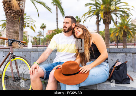 Espagne, Barcelone, affectionate couple sitting on bench relaxing Banque D'Images
