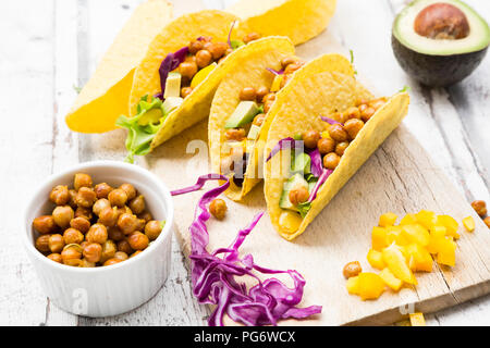 Tacos végétariens rempli de pois chiches rôtis au curcuma, paprika jaune, avocat, salade de chou rouge et Banque D'Images