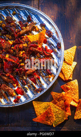 Chili con Carne avec des croustilles sur bac aluminium grill Banque D'Images