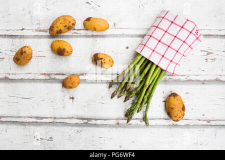 Les asperges vertes et les pommes de terre sur le bois blanc Banque D'Images
