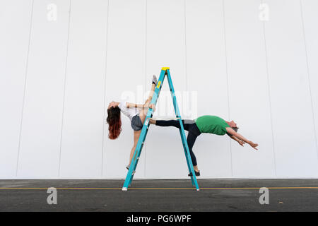 Deux acrobates faisant des tours sur une échelle Banque D'Images