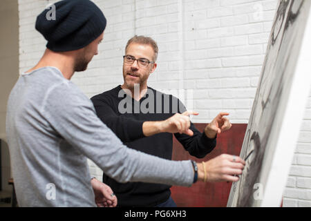 Dessin artiste discuter avec l'homme en studio Banque D'Images