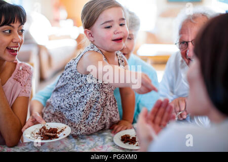 Les grands-parents fêter un anniversaire avec leur petite-fille, manger du gâteau au chocolat Banque D'Images