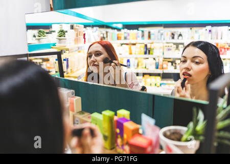 Deux femmes dans une boutique de cosmétiques d'essayer de Banque D'Images
