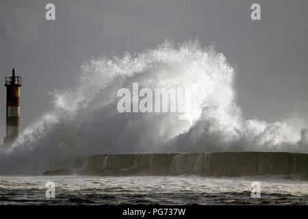 Grosse Vague contre phare dans le nord du Portugal dans un ciel couvert soir orageux - embouchure de la rivière Ave à Vila do Conde Banque D'Images