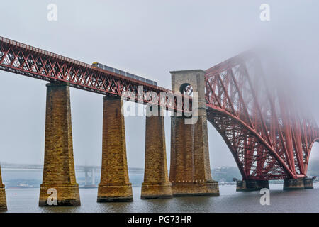 FORTH RAILWAY BRIDGE SUR LE Firth of Forth EN ÉCOSSE TRAIN TRAVERSANT LE PONT DANS LA BRUME MATINALE Banque D'Images