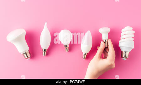 Cropped shot de main humaine et divers types d'ampoules sur Rose Banque D'Images