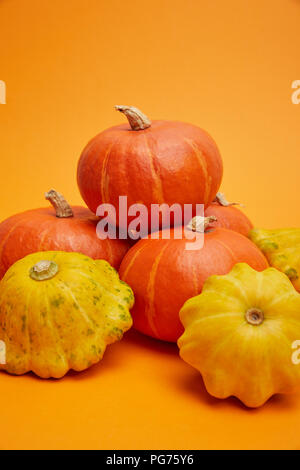 Vue rapprochée de tas de matières premières citrouilles fraîches mûres sur orange Banque D'Images