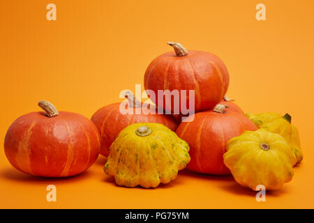 Des tas de citrouilles mûrs sur fond orange Banque D'Images