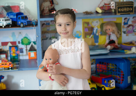 Biélorussie, Minsk, le 30 mai 2018. Le centre de l'école maternelle. Journée portes ouvertes.une fille d'âge préscolaire dans un jardin avec une poupée Banque D'Images