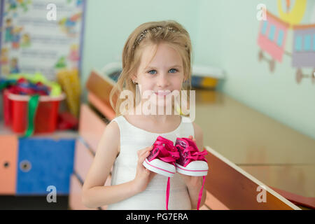 Biélorussie, Minsk, le 30 mai 2018. Le centre de l'école maternelle. Journée portes ouvertes.belle fille d'âge préscolaire avec toy sneakers Banque D'Images