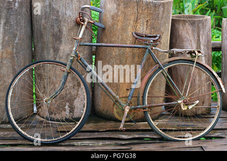 Un vieux antique retro vintage bicycle leaning against clôture en bois Banque D'Images