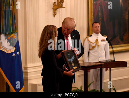 Le président Donald J. Trump remet la Médaille d'honneur de Valerie Nessel, le conjoint de l'US Air Force Tech. Le Sgt. John Chapman, lors d'une cérémonie à la Maison Blanche à Washington, D.C., le 22 août, 2018. Le sergent Chapman a reçu à titre posthume la Médaille d'Honneur pour des actions sur Takur Ghar mountain en Afghanistan le 4 mars 2002. Son équipe d'élite des opérations spéciales est tombé dans une embuscade tendue par l'ennemi et est venu sous un feu nourri provenant de multiples directions. Chapman immédiatement débité un ennemi par bunker-cuisse de la neige profonde et a tué tous les occupants de l'ennemi. Déménagement avec courage, d'une couverture à l'assault d'une deuxième machine Banque D'Images