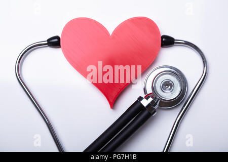 L'examen de Cœur Rouge avec stéthoscope sur fond blanc Banque D'Images