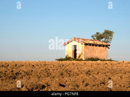 Un bâtiment de ferme sur le sommet d'une légère pente dans un champ labouré à la campagne dans le département du Tarn France Banque D'Images