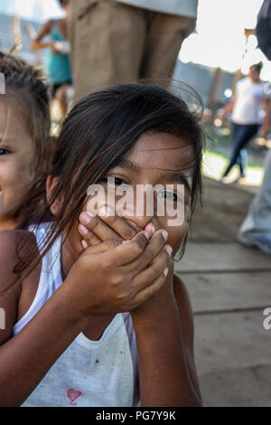 Une jeune fille joue dans l'attente de nourriture à distribuer par missionnaires américains en Amérique centrale. Banque D'Images