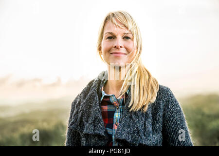 Smiling woman standing in dunes Banque D'Images