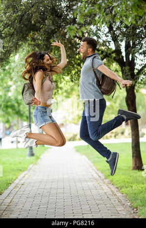 Carefree couple jumping in park Banque D'Images