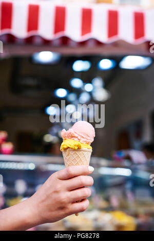 Woman's hand holding ice cream cone avec deux boules Banque D'Images