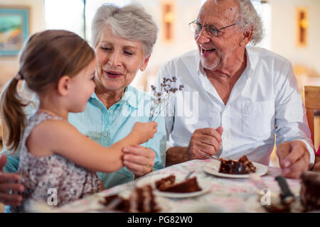 Les grands-parents fêter un anniversaire avec leur petite-fille, manger du gâteau au chocolat Banque D'Images