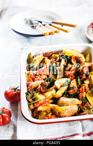 Cocotte de pommes de terre, épinards, tomates et chorizzo Banque D'Images