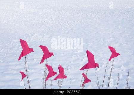 Oiseaux Origami assis sur l'herbe en hiver Banque D'Images