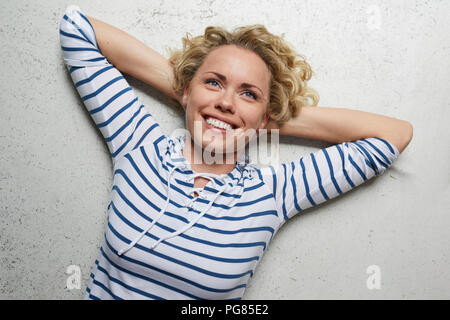 Portrait of happy woman with hands behind head Banque D'Images