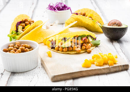 Tacos végétariens rempli de pois chiches rôtis au curcuma, paprika jaune, avocat, salade de chou rouge et Banque D'Images