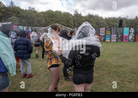 Bramham Park, Royaume-Uni. 24 août 2018, UK Weather. Les gens à l'abri de la pluie torrentielle à Leeds Festival durant une tempête de grêle, Yorkshire, Royaume-Uni. © Jason Richardson / Alamy Live News Banque D'Images
