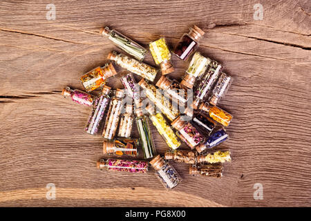 Diverses sortes de thé et herbes curatives dans des bouteilles en verre clair sur Banque D'Images