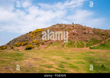 Les touristes et les marcheurs profiter du sommet de Arthur's Seat à Holyrood Park, Edinburgh, Ecosse, Royaume-Uni. Banque D'Images