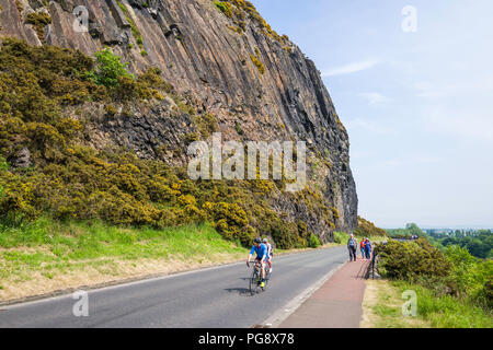 Les cyclistes et les marcheurs sur Duddingston Low Road sous les falaises de Arthur's Seat. La route liens Duddingston Village avec centre d'Édimbourg. Banque D'Images