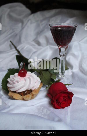 Gâteau à la crème à la rose et l'arôme du vin rouge dans le verre cristal pour beau cadeau romantique ou dessert Banque D'Images