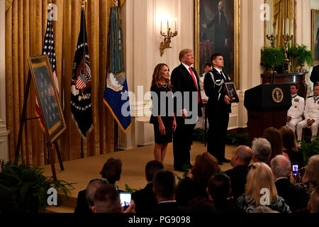 Valerie Nessel, le conjoint de l'US Air Force Tech. Le Sgt. John Chapman, se distingue comme la citation est lue avant de recevoir la médaille d'honneur du président Donald J. Trump lors d'une cérémonie à la Maison Blanche à Washington, D.C., le 22 août, 2018. Le sergent Chapman a reçu à titre posthume la Médaille d'Honneur pour des actions sur Takur Ghar mountain en Afghanistan le 4 mars 2002. Son équipe d'élite des opérations spéciales est tombé dans une embuscade tendue par l'ennemi et est venu sous un feu nourri provenant de multiples directions. Chapman immédiatement débité un ennemi par bunker-cuisse de la neige profonde et a tué tous les occupants de l'ennemi. Movin avec courage Banque D'Images