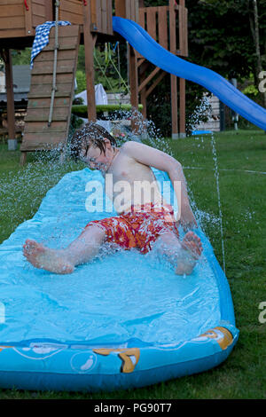 Garçon sur le toboggan, Neuenkleusheim, Olpe, Rhénanie du Nord-Westphalie, Allemagne Banque D'Images