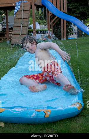 Garçon sur le toboggan, Neuenkleusheim, Olpe, Rhénanie du Nord-Westphalie, Allemagne Banque D'Images