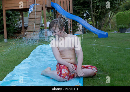 Garçon sur le toboggan, Neuenkleusheim, Olpe, Rhénanie du Nord-Westphalie, Allemagne Banque D'Images