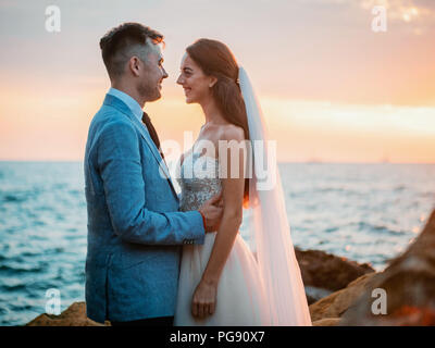 Belle jeune couple debout sur la mer avec des pierres. Les nouveaux mariés passent du temps ensemble : embrasser, baiser et prendre soin les uns des autres. Concept d'amour. B Banque D'Images