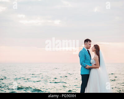 Belle jeune couple debout sur la mer avec des pierres. Les nouveaux mariés passent du temps ensemble : embrasser, baiser et prendre soin les uns des autres. Concept d'amour. B Banque D'Images