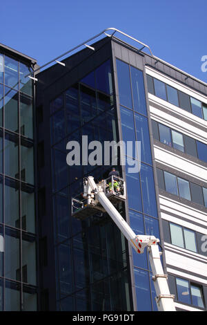Nettoyage de vitres à travailler sur une tour moderne bâtiment de verre Banque D'Images