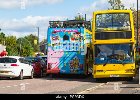 Compression serrée pour deux bus jaune passant en route avec des voitures en stationnement dans la région de Westbourne, Bournemouth, Dorset en Août Banque D'Images