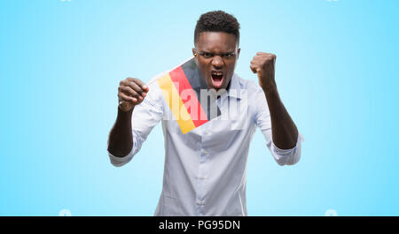 Young african american man drapeau allemand contrarié et frustré de crier avec colère, fou et hurlant de main levée, la colère concept Banque D'Images