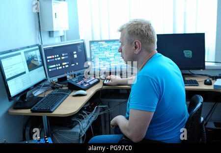 Ingénieur vidéo montage vidéo assis en face de moniteurs à l'agence de presse studio. Le 10 août 2018. Kiev, Ukraine Banque D'Images