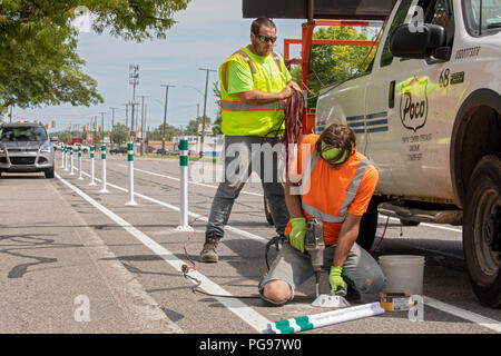 Detroit, Michigan - installer des bornes comme ils construire des voies cyclables sur une rue animée. La ville est considérablement élargir les pistes cyclables protégées Banque D'Images